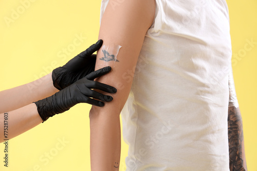 Tattoo master applying crea...