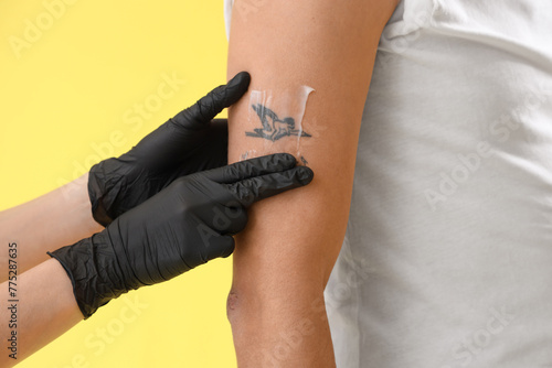 Tattoo master applying crea...