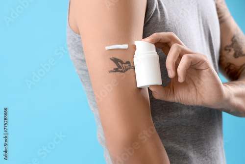 Young man applying tattoo c...