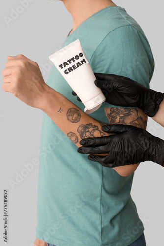Tattoo master with tube of ...