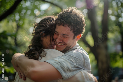 A man and woman hugging each other with trees in the background