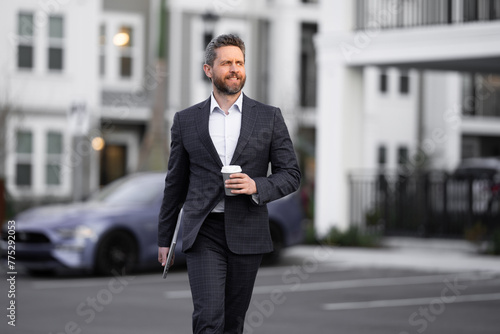 Business man in suit. Businessman walking in city. Hispanic man walk on street. Business man with laptop and coffee walking outdoor. Business man in suit go to office work. Success business.