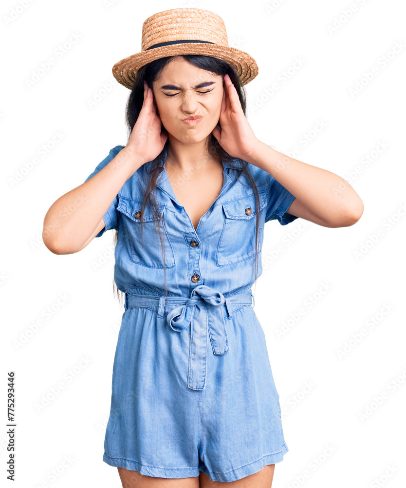 Brunette teenager girl wearing summer hat covering ears with fingers with annoyed expression for the noise of loud music. deaf concept. Brunette teenager girl wearing summer hat covering ears with fingers with annoyed expression for the noise of loud music. deaf concept.