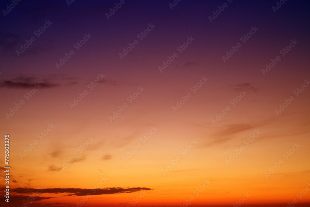 Orange sky background with dark clouds at sunset on a summer evening	