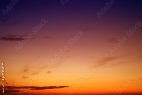 Orange sky background with dark clouds at sunset on a summer evening	