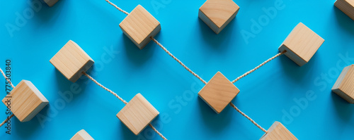 Wooden blocks connected by string on blue background.