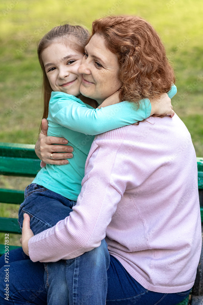 Fototapeta premium Mother and daughter hugging in the park in summer.