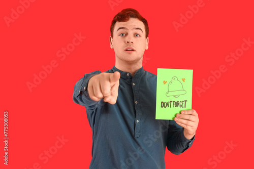 Young man holding paper wit...