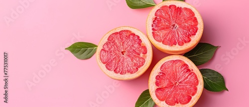  A pink surface features green-topped halved grapefruits with leaves