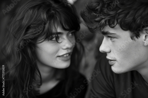 A black and white photo of a man and a woman looking at each other
