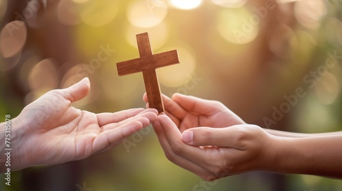 Christian proselytizing, hands of Christian man holding and passing wooden cross to woman's hands, great commission concept. photo