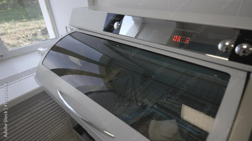 Working quartz sterilizer with medical instruments inside. Hospital employee sterilizes medical tools before surgery in sterilization room Working quartz sterilizer with medical instruments inside. Hospital employee sterilizes medical tools before surgery in sterilization room