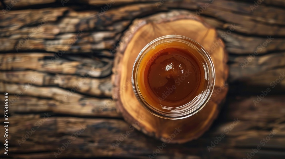 A jar of liquid sitting on a wooden table. Suitable for various concepts and designs A jar of liquid sitting on a wooden table. Suitable for various concepts and designs