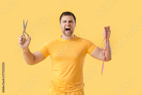 Angry young man with scisso...