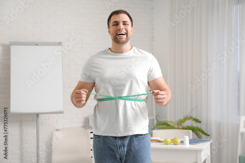 Young man measuring his wai...