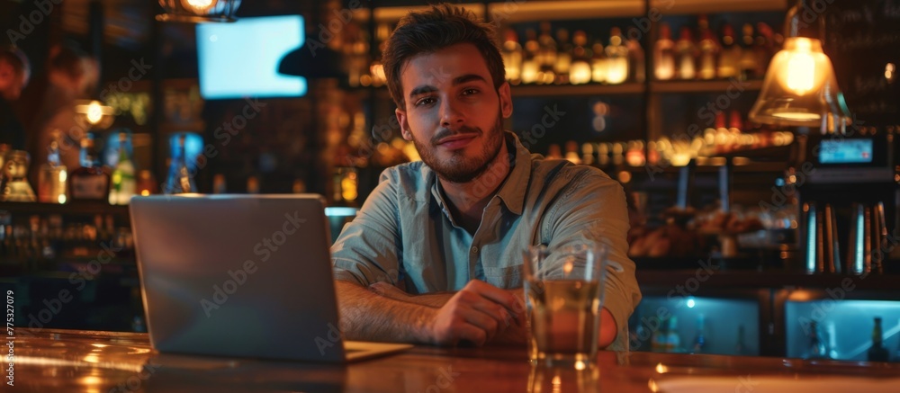 Man seated in a bar with laptop