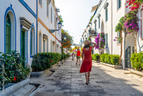 Konstfotografi A woman walking in the port of the coastal town Mogan in the south of Gran Canaria