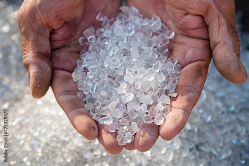 A pair of human hands gently holds a cluster of raw silica crystals, illuminated by natural sunlight
