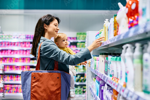 Obraz na plátně Small girl and her mother shopping in supermarket.