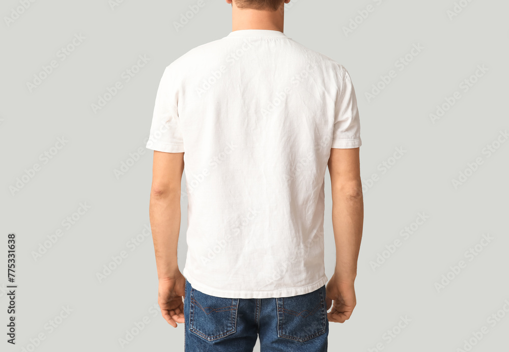 Fototapeta premium Man in stylish t-shirt on light background, back view