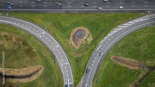 
entrance and exit on Dutch Highway road A12 at Reeuwijk near Gouda in Netherlands. Traffic flows at efficient pace with cars in lanes entering and exiting motorway. drone aerial view of transport
