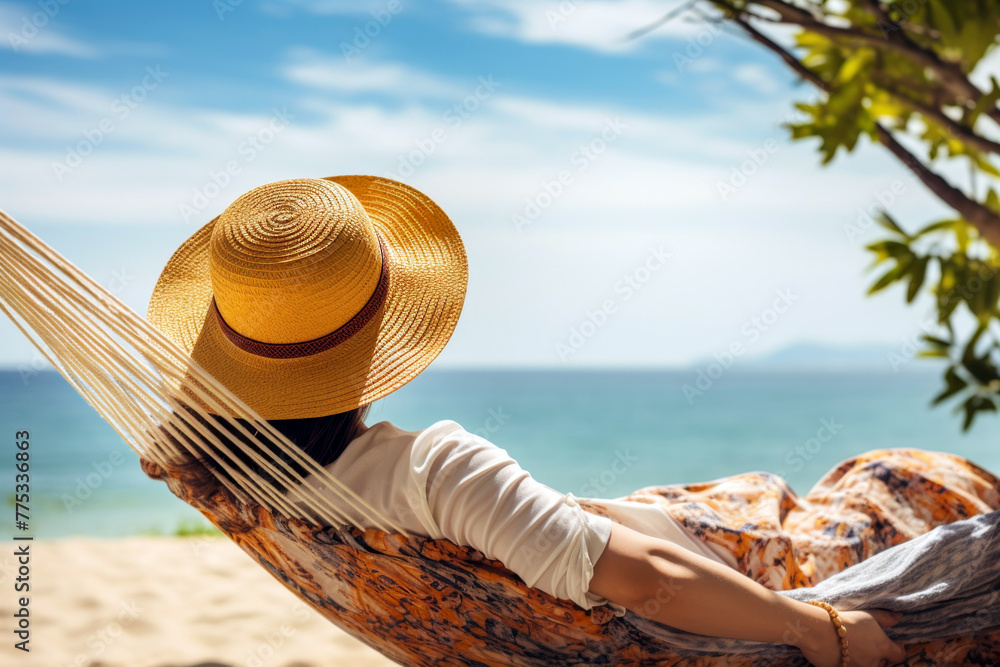 Obraz premium A woman relaxing in a hammock by the beach. Concept of relaxation, vacation, and the simple joys of a seaside retreat.