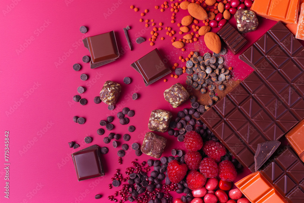 Table with various chocolates with raspberries on a pink table Table with various chocolates with raspberries on a pink table