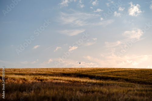 Einsamer kleiner Hei  luftballon am Horizont   ber einem Feld bei Sonnenuntergang