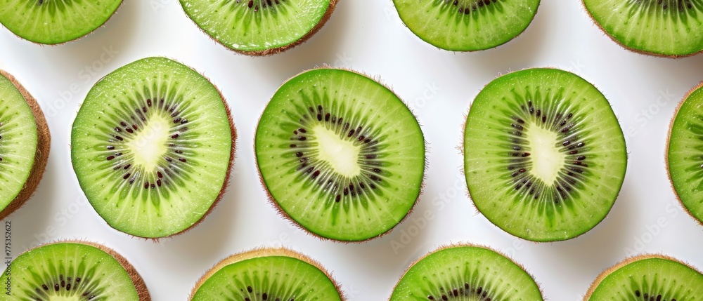 Fototapeta premium A group of kiwis sliced in half stacked on top of each other on a white countertop
