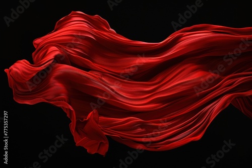 Red drape falling like wings isolated on flat black background. Beautiful red fabric with pleats floats in air
