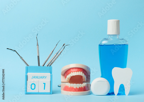 Plastic bottle with mouthwash, dentist medical instruments on blue background