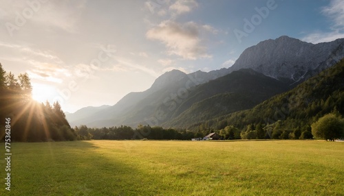 green grass field near mountain on sunny day in zgornje jezersko kranj slovenia photo