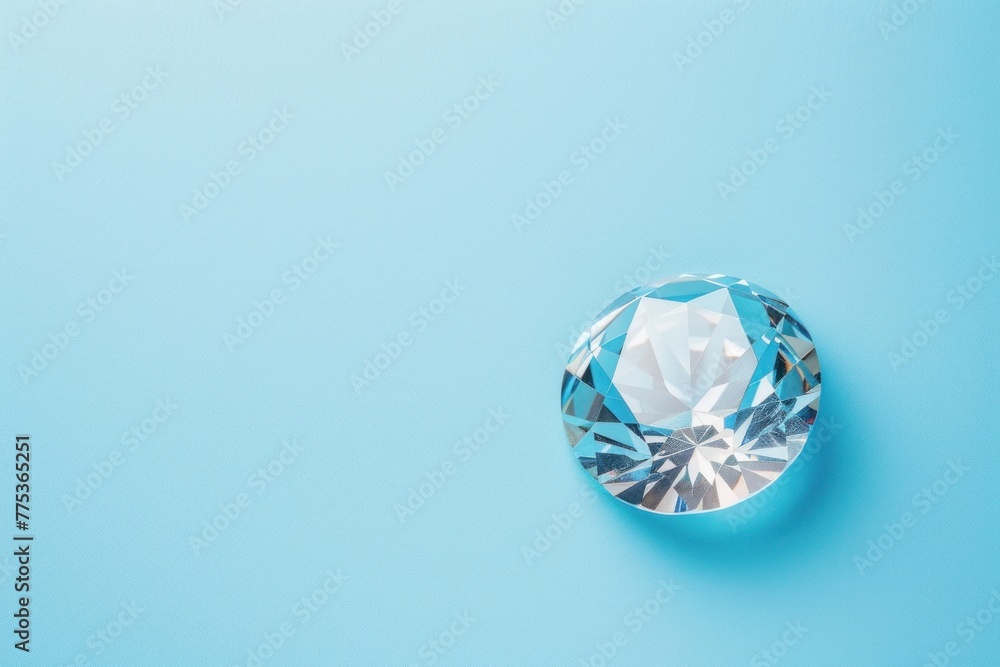 Top view of one beautiful brilliant gemstone with facets isolated on a flat pastel blue background with copy space Top view of one beautiful brilliant gemstone with facets isolated on a flat pastel blue background with copy space