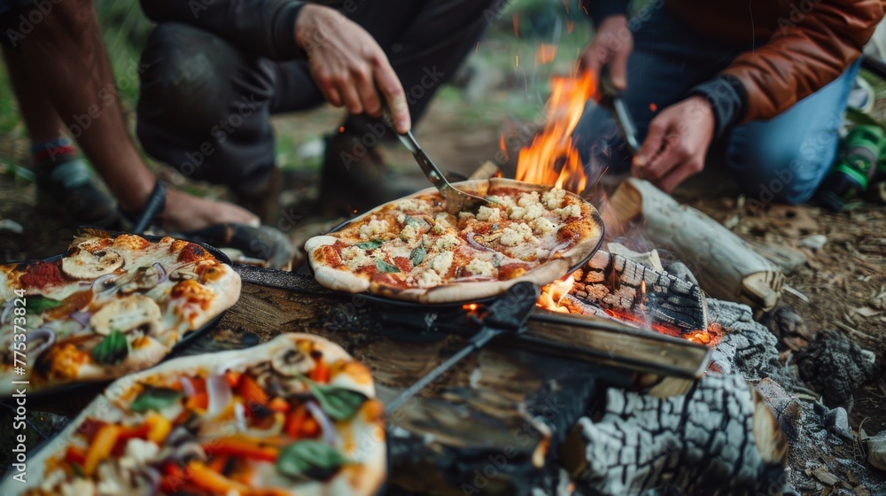 Friends preparing delicious homemade pizza on an open campfire in the great outdoors