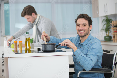 Photos happy disabled man is cooking pasta