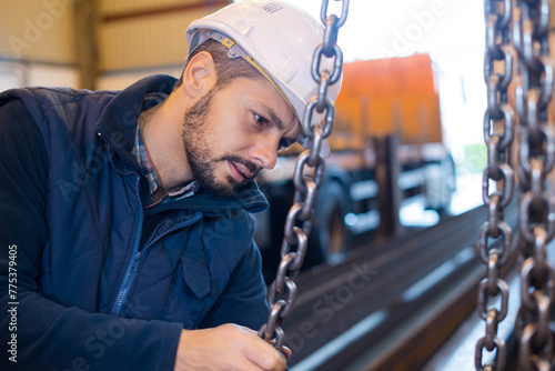 car mechanic worker hands pulling chains photo