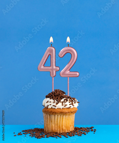 Birthday candle with cupcake on blue background - Number 42