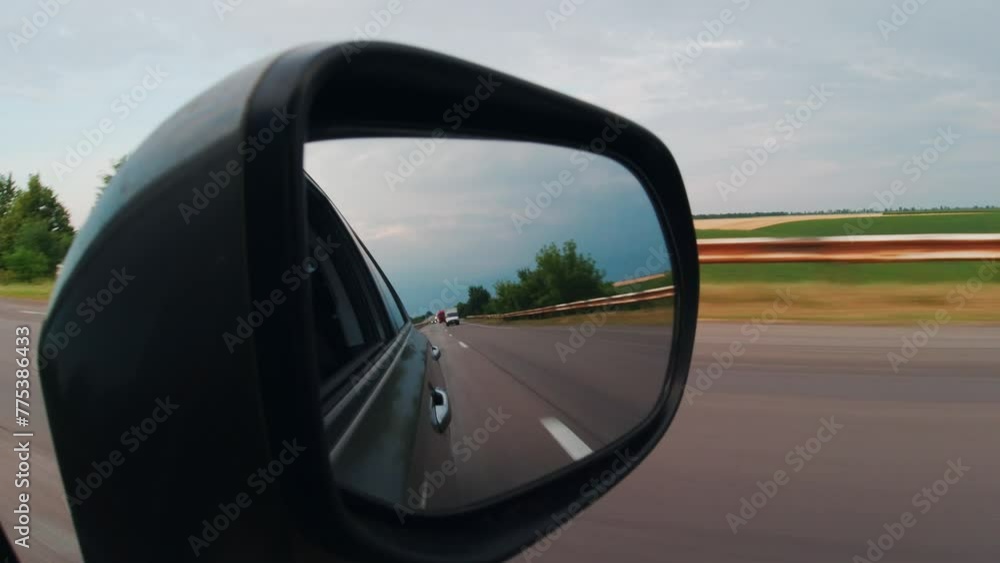 View in the rear view mirror of a car View in the rear view mirror of a car