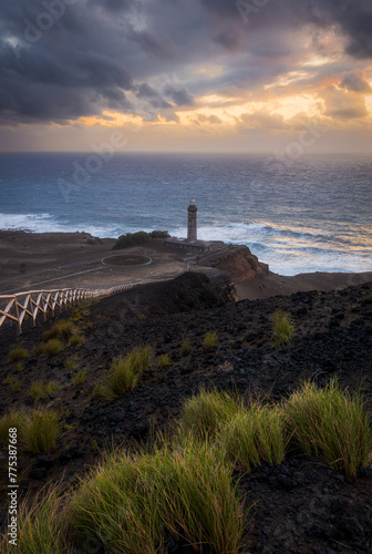Ponta dos Capelinhos lighthouse on western coast of Faial island, Azores, Portugal, at sunset