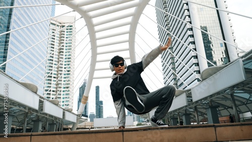 Young asian hipster show footstep at city center surround by people. Stylish fashion street dancer perform B-boy or freestyle dancing with low angle. Outdoor sport 2024. Break dancing. Sprightly.