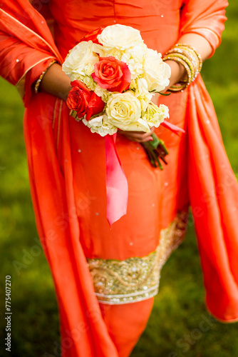 Indian bridesmaid holds rose bouquet