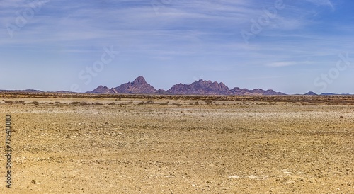Panoramic picture of the Spitzkoppe in Namibia during the day against a blue sky