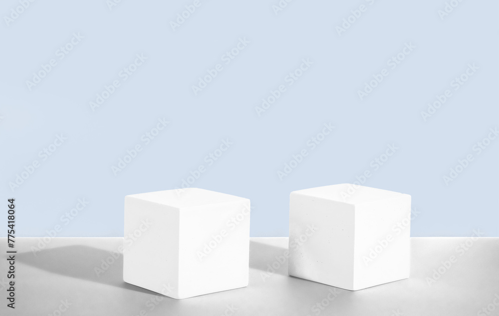 Cosmetic light blue background with geometric shapes. Two white cement cubic podiums. Mockup for the demonstration of cosmetic products Cosmetic light blue background with geometric shapes. Two white cement cubic podiums. Mockup for the demonstration of cosmetic products