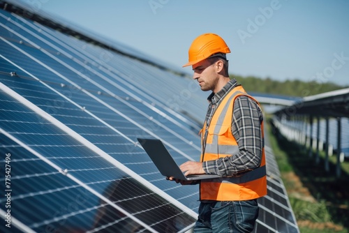 a man in a vest and hard hat standing in front of solar panels