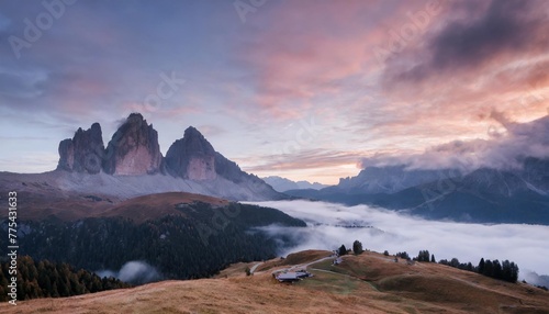 mountains in fog at beautiful sunset in autumn in dolomites italy landscape with alpine mountain valley low clouds trees on hills purple sky with clouds at dusk aerial view passo giau nature