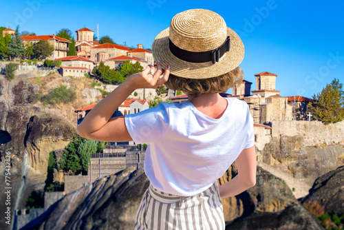 Woman tourist in Cyprus. Girl with her back to camera. Woman admires houses on cliffs. Traveler near resort of Pissouri. Tourist on island of Cyprus. Holidays in village of Pissouri. photo