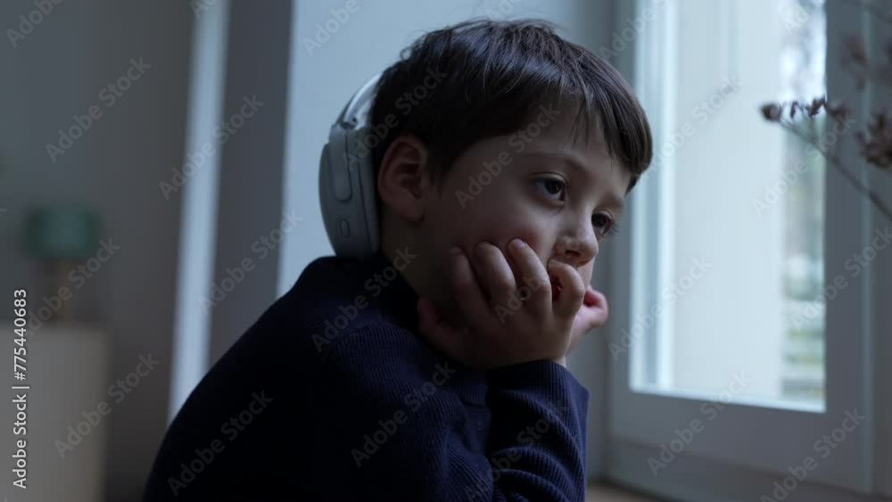 Thoughtful small boy with hand in chin daydreaming at home by window. Pensive child thinking deeply absorbed in introspective thoughts Thoughtful small boy with hand in chin daydreaming at home by window. Pensive child thinking deeply absorbed in introspective thoughts