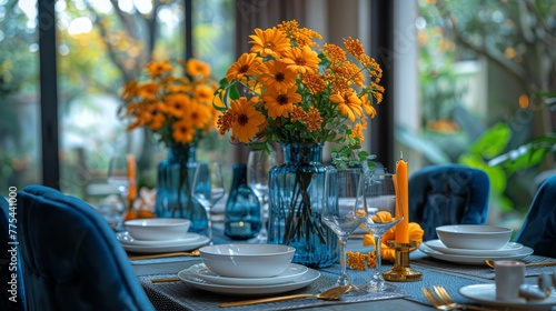   A formal dinner table with blue chairs and yellow flowers in vases on top photo