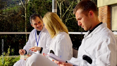 Group of doctors having a break outdoors. People resting outside the hospital.