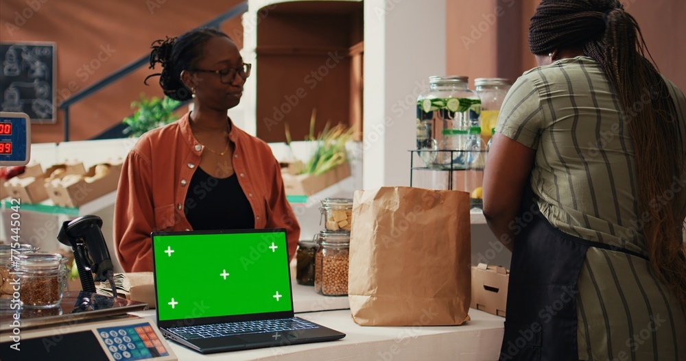 Retailer having laptop that shows greenscreen on display at cash ...